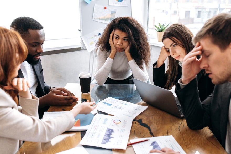 Businesses reflect on Google algo update Group of people looking stressed around a work table as if trying to solve a problem