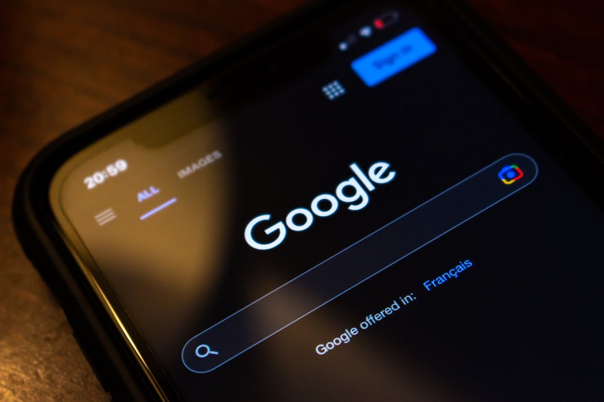 Google AI Overviews expansion Mobile showing the Google search homepage in dark mode