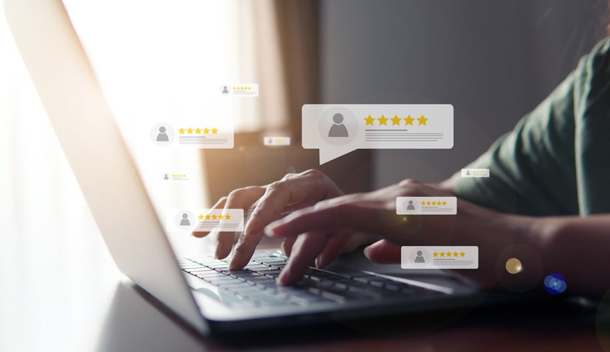 Google Store Ratings Person typing at a laptop with floating customer reviews around the hand