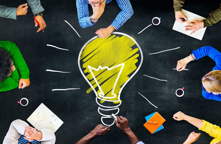 July website ideas Lightbulb drawn on a chalkboard table with people gathered around it