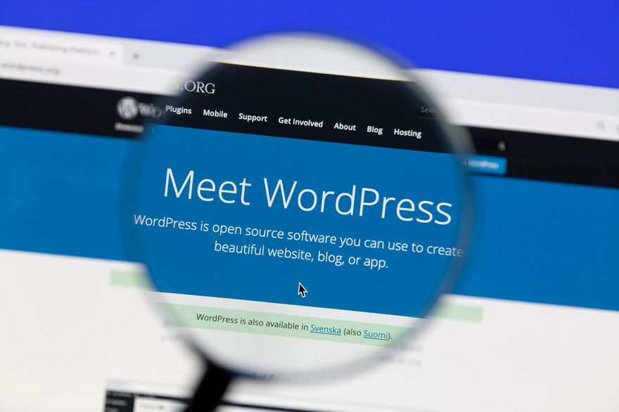 Should WP Engine users switch Magnifying glass held over screen showing WordPress homepage