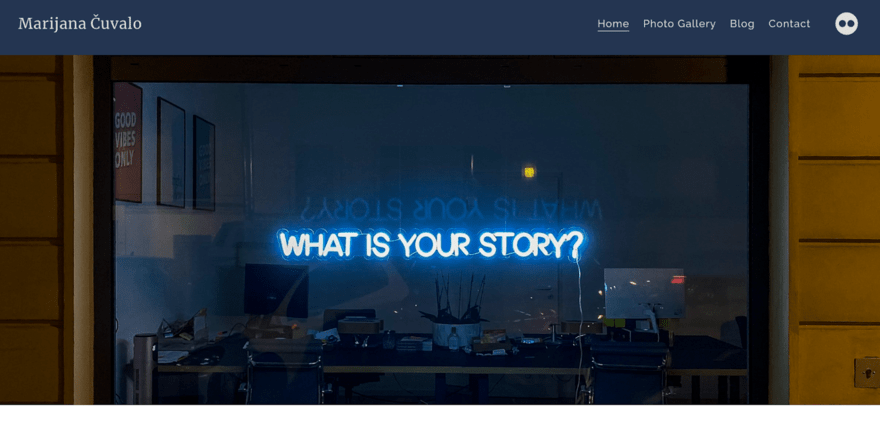 Website homepage Neon sign asking "WHAT IS YOUR STORY?" visible through a window reflecting the night sky, adjacent to a yellow door.